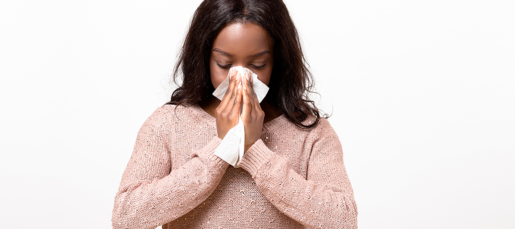 Woman with allergies blowing her nose