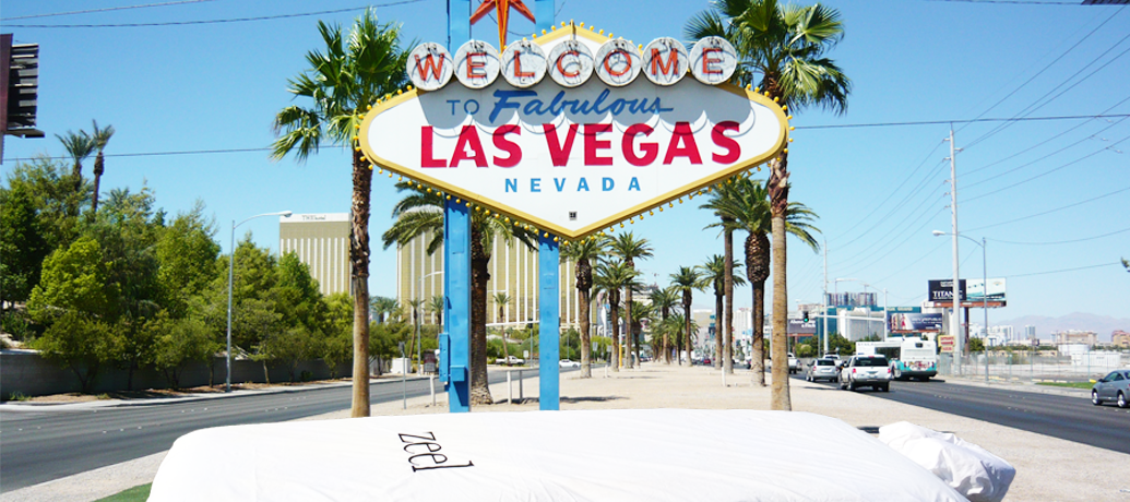 Classic 'Welcome to Fabulous Las Vegas Nevada" sign stands invitingly in the sun against palm trees