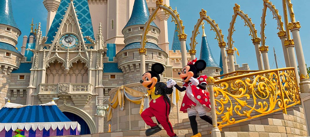 Mickey Mouse and Minnie Mouse run down the steps of Cinderella's Castle at Walt Disney World in Orlando, Florida.