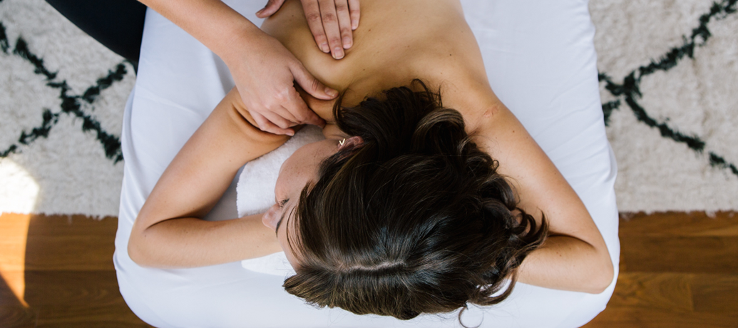 Woman relaxes into the massage table as she receives a quality Zeel massage in the comfort of her own home.