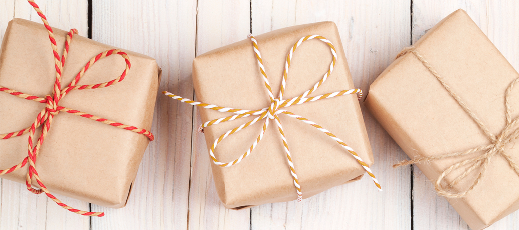 Gifts wrapped in kraft paper and packaged with striped twine bows are ready to be sent off for back-to-school gifts.