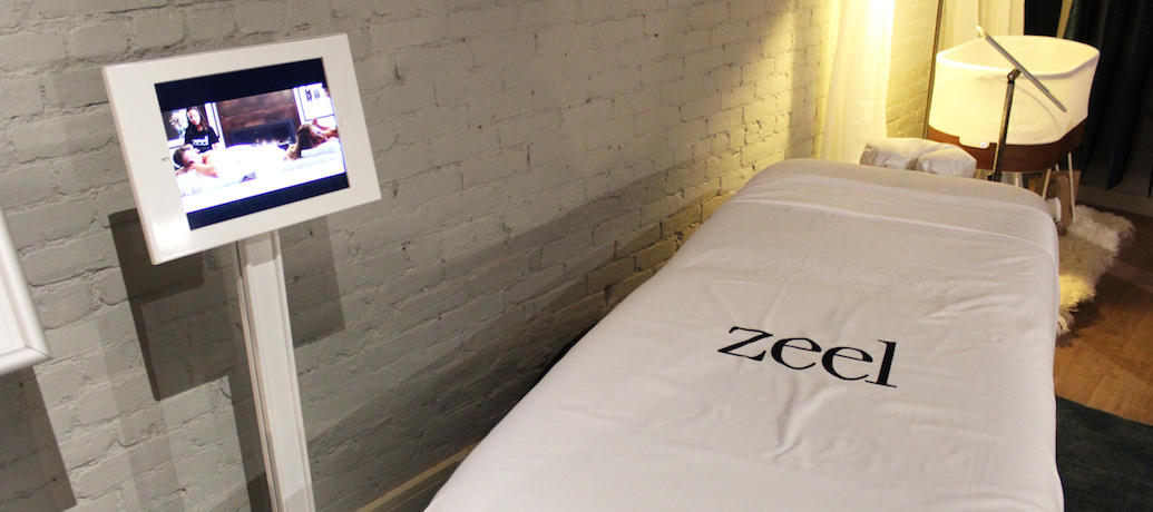 A massage table with Zeel sheets and an iPad with a Thrive Global app loaded await a client.