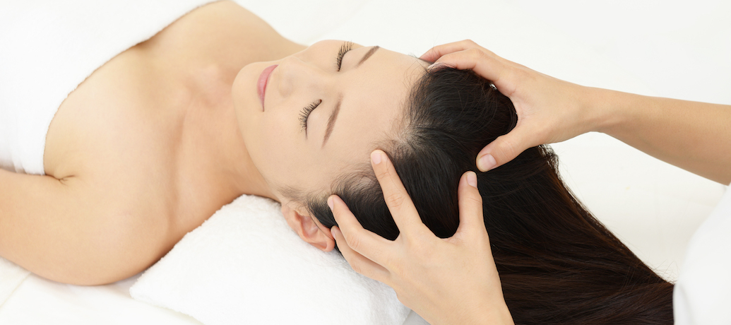 Woman gets scalp massage on table