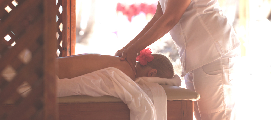 Woman giving a female customer a Zeel Massage on the beach