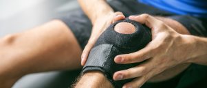 Man with knee pain wearing knee brace