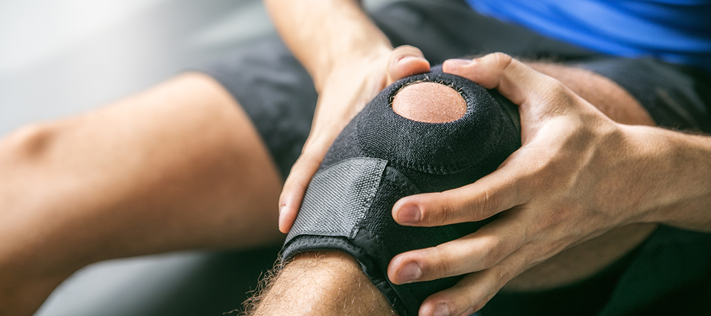 Man with knee pain wearing knee brace