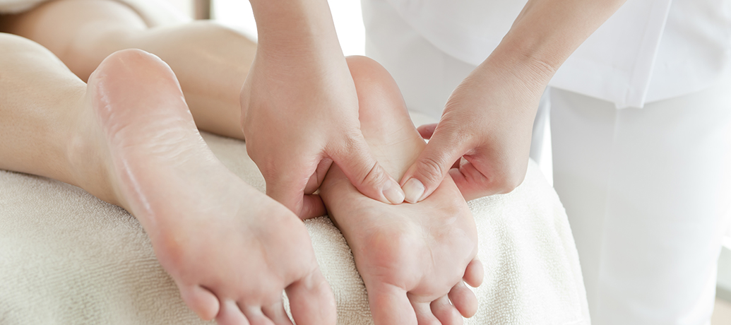applying pressure to feet with reflexology table massage