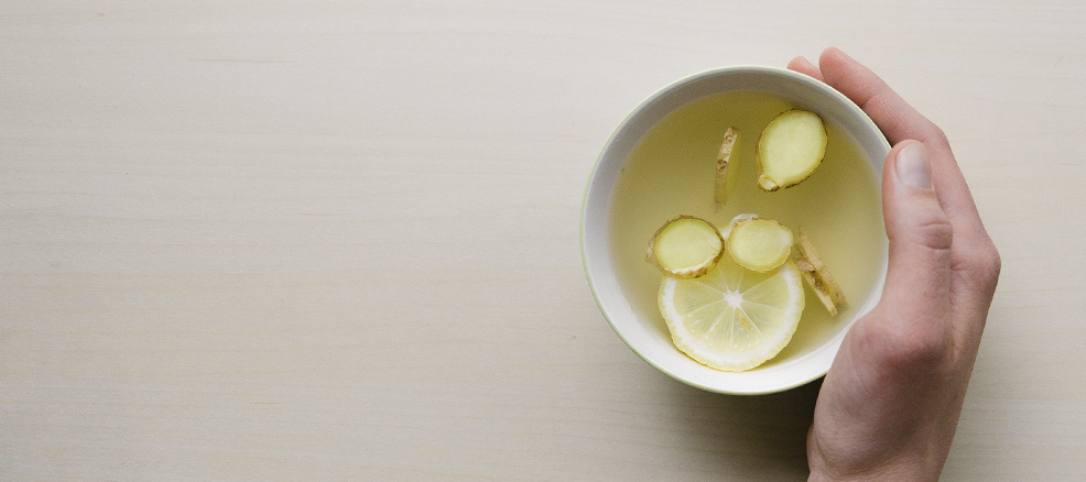 A woman drinking tea to help with her bloat and inflammation.