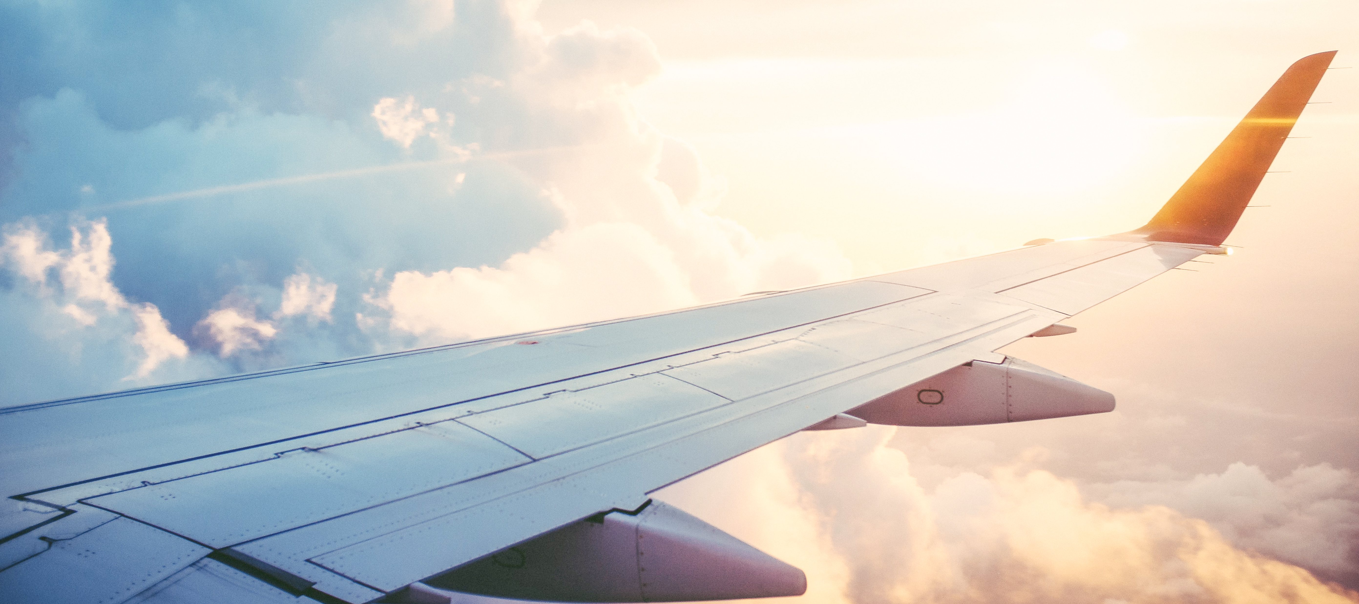 A close up of the wing of an airplane flying through the air.