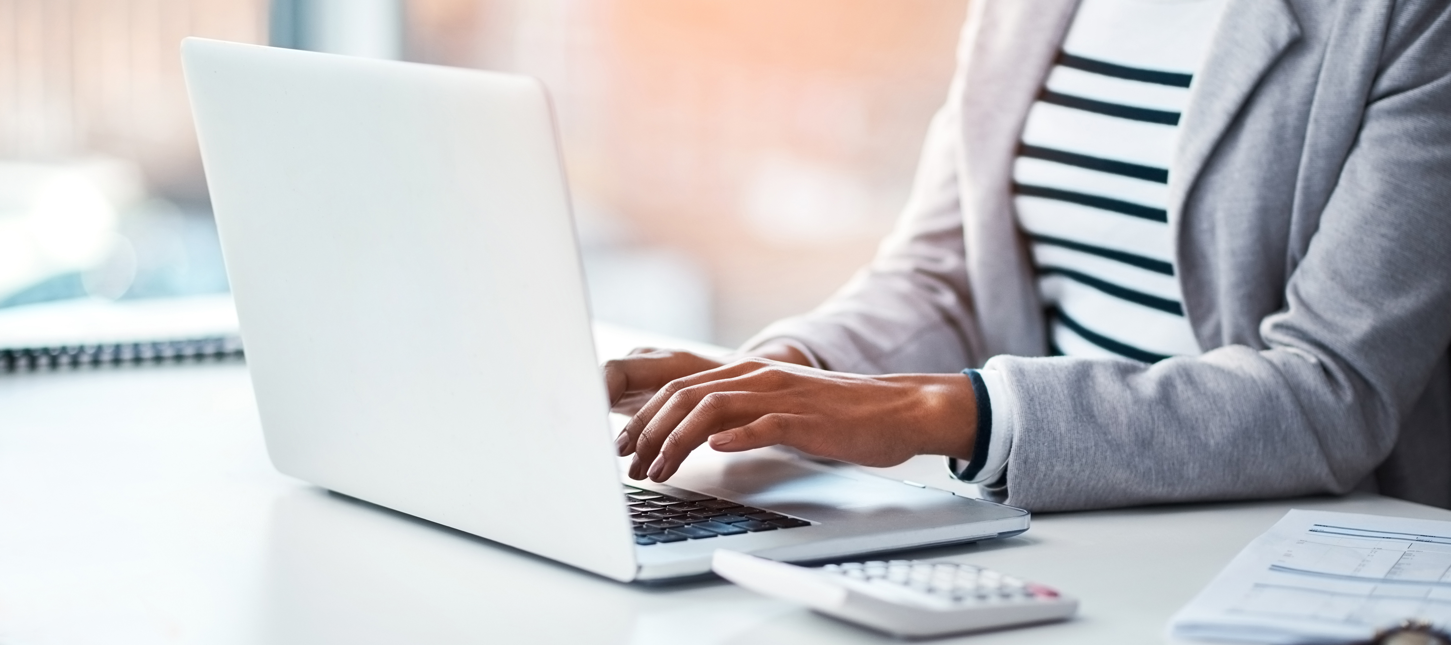 A woman happily working at her desk due to her positive work environment.