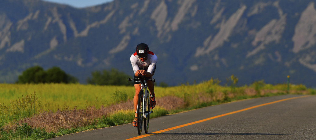 A person on a bicycle doing the Ironman challenge.