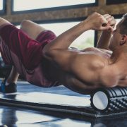A man massaging his back with a Foam Rollers