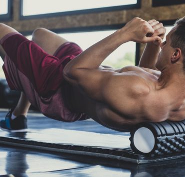 A man massaging his back with a Foam Rollers