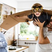 A father holding his son up in the air as they play together.