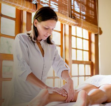 A massage therapist treating a patient with health insurance after acquiring their NPI number.
