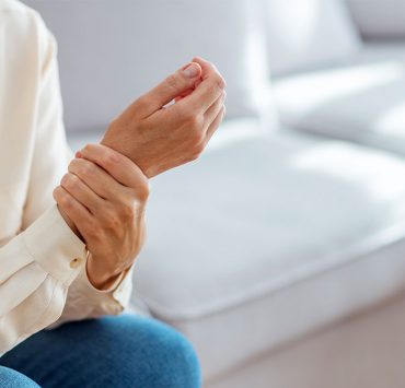 An older woman holding her wrist due to her arthritis pain.
