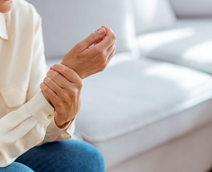An older woman holding her wrist due to her arthritis pain.
