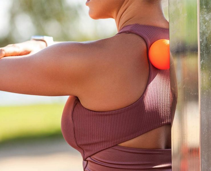 A woman standing outside in athletic wear.