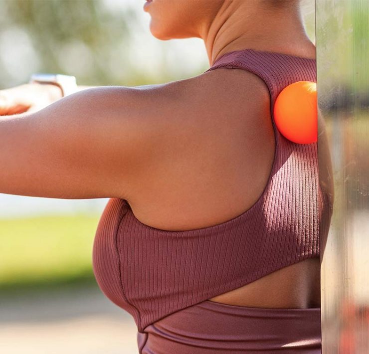 A woman standing outside in athletic wear.