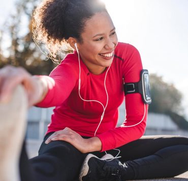 A runner taking a break to stretch out her leg muscles.