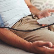 A man checking his blood pressure to see if he's experiencing hypertension.