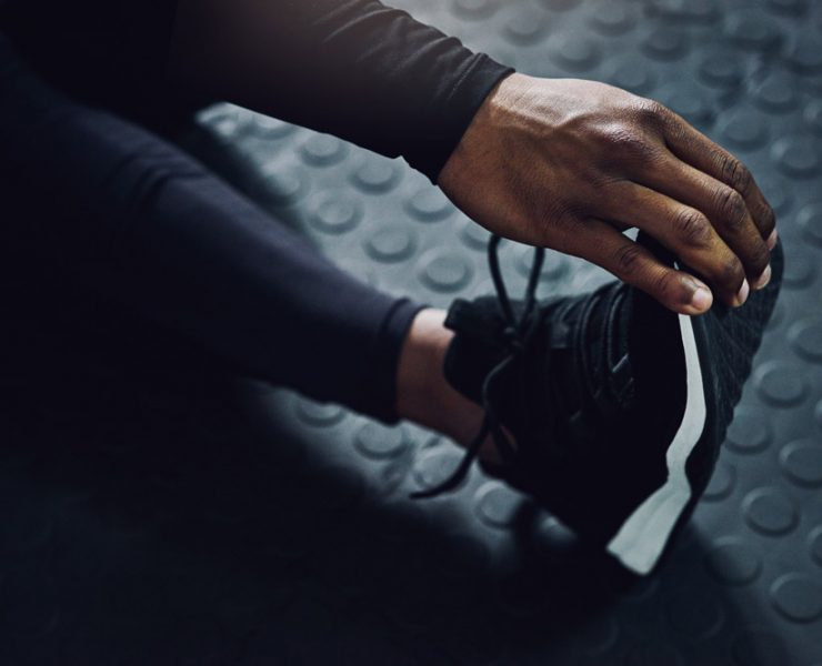 A woman stretching out her legs before she begins her workout.