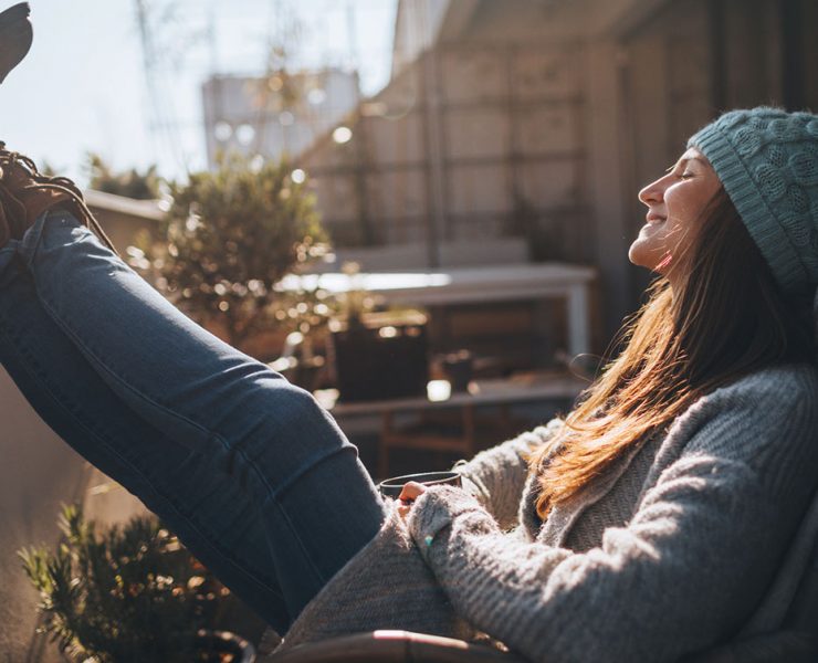 A woman sitting outside in winter clothing.