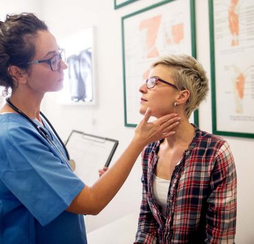A woman getting a check-up with her doctor to assess to prognosis of her autoimmune disease.