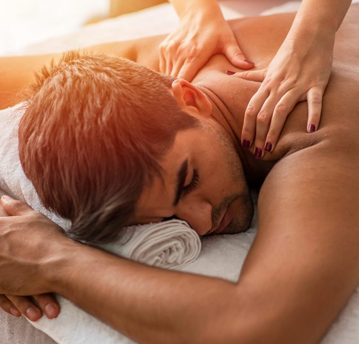 A man laying in bed receiving an in-Home Massage.
