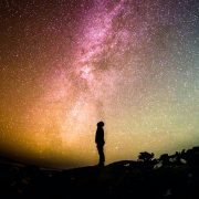 A person meditating outside under the stars as the practice mindfulness techniques.