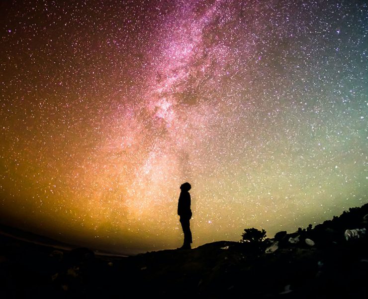 A person meditating outside under the stars as the practice mindfulness techniques.