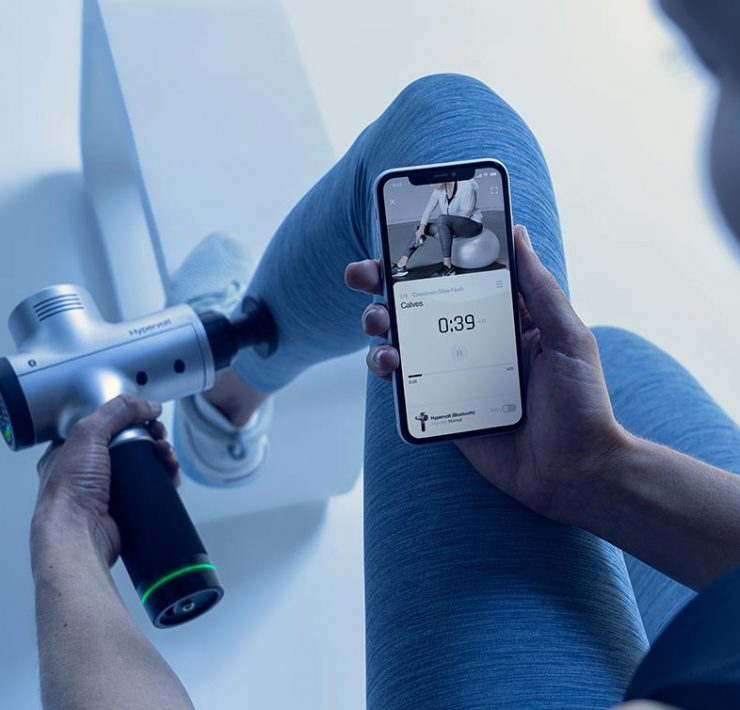 A woman using a self massage tool to help her with pain relief in her leg.