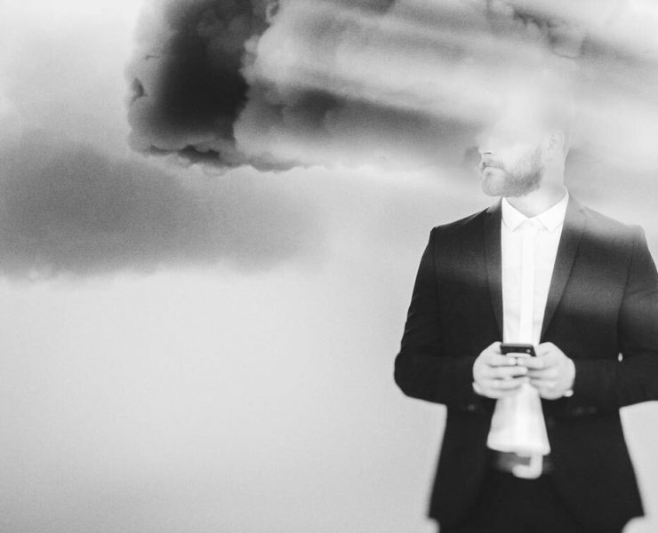 A man in a suit with his face blurred out to demonstrate brain fog.