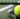 A tennis racket and ball are sitting on the court after the owner sat them down to stretch.
