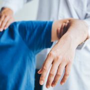 A man getting his shoulder massaged to help ease the pain from he's experiencing from frozen shoulder.