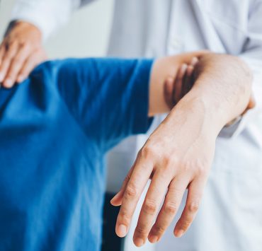 A man getting his shoulder massaged to help ease the pain from he's experiencing from frozen shoulder.
