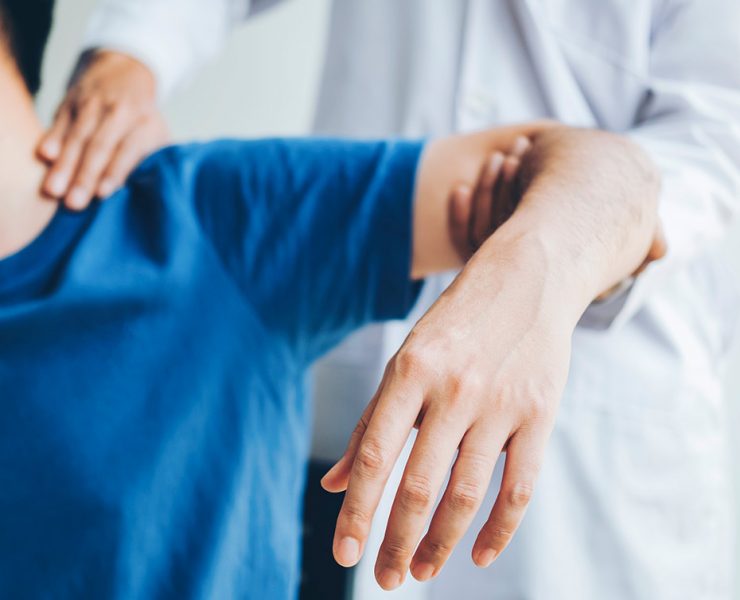 A man getting his shoulder massaged to help ease the pain from he's experiencing from frozen shoulder.