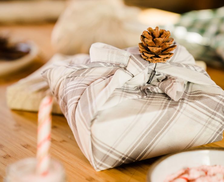 A wrapped holiday gift sitting on the dinner table.