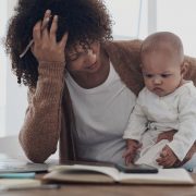 A mother who is dealing with stress and burnout trying to care for her baby while also working from home.