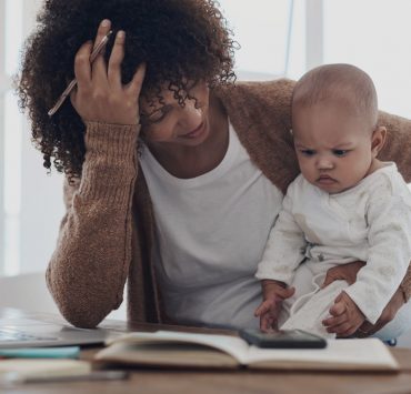 A mother who is dealing with stress and burnout trying to care for her baby while also working from home.