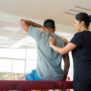 A provider in the helping a patient iduring their medical massage before writing her SOAP notes.
