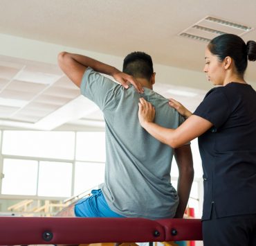 A provider in the helping a patient iduring their medical massage before writing her SOAP notes.