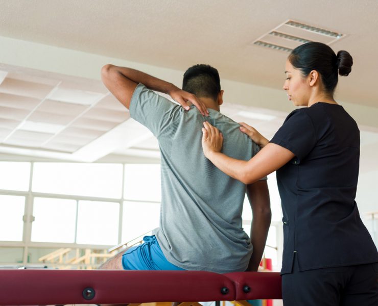 A provider in the helping a patient iduring their medical massage before writing her SOAP notes.