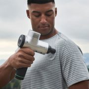 An athlete using the Hypervolt 2 percussion massage device by Hyperice to help them with their home recovery after training.