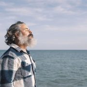 Man looking peaceful in front of the ocean - lowering cortisol naturally
